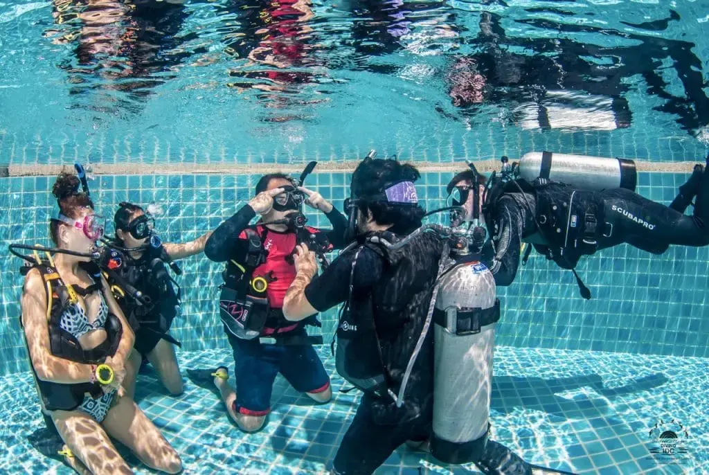 Practising basic scuba skills in shallow water before the open water dive