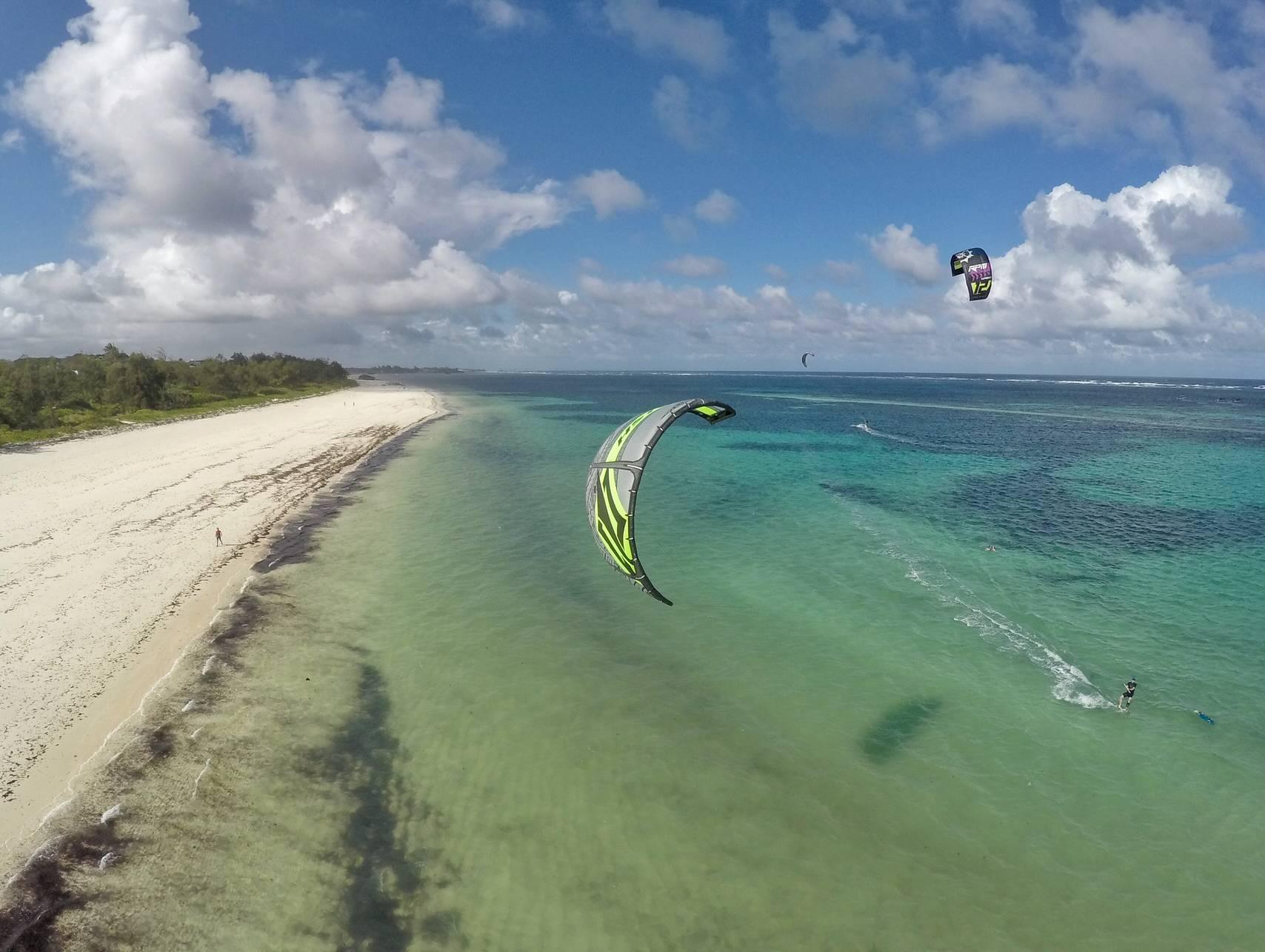 Kite surfers riding across the shallow turquoise lagoon in Watamu, Kenya