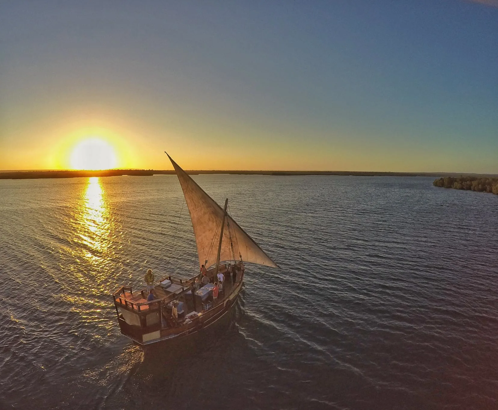 Traditional wooden dhow sailing across Watamu waters during sunset