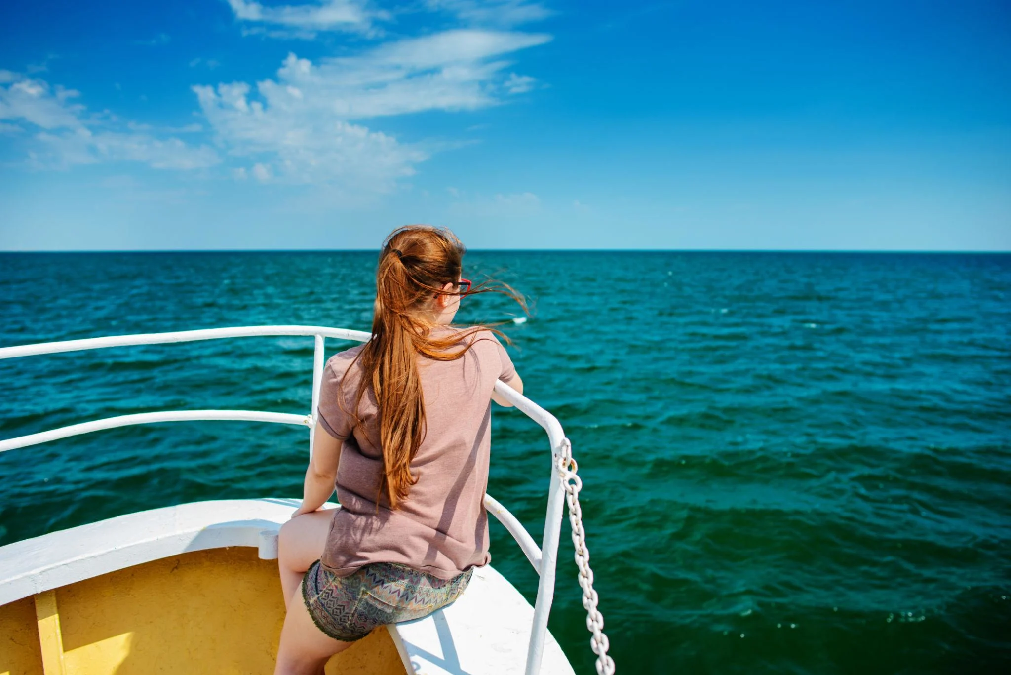 Passenger looking at the horizon to help manage seasickness on a boat